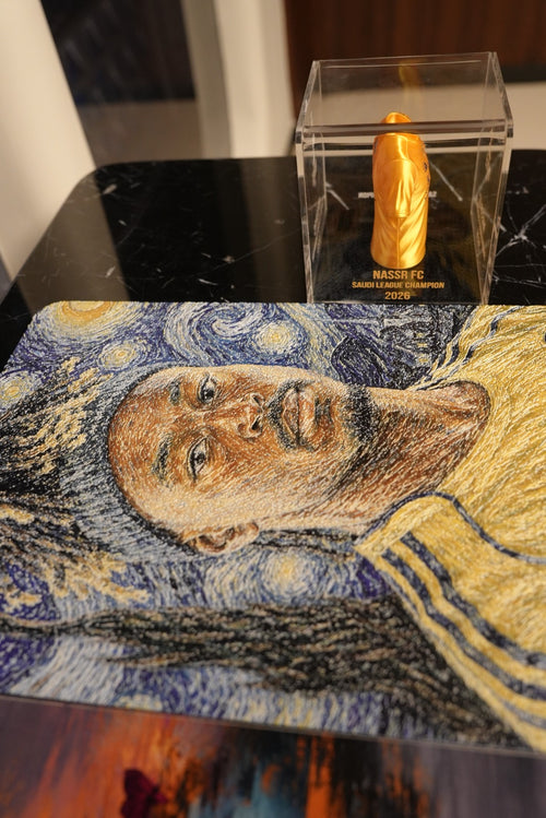 Al Nassr FC embroidered Starry Night displayed on marble surface alongside Saudi League Champion 2026 mini jersey
