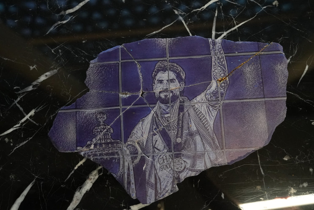 Al Nassr FC laser-engraved stone slab — champion player portrait with gold kintsugi cracks on marble surface