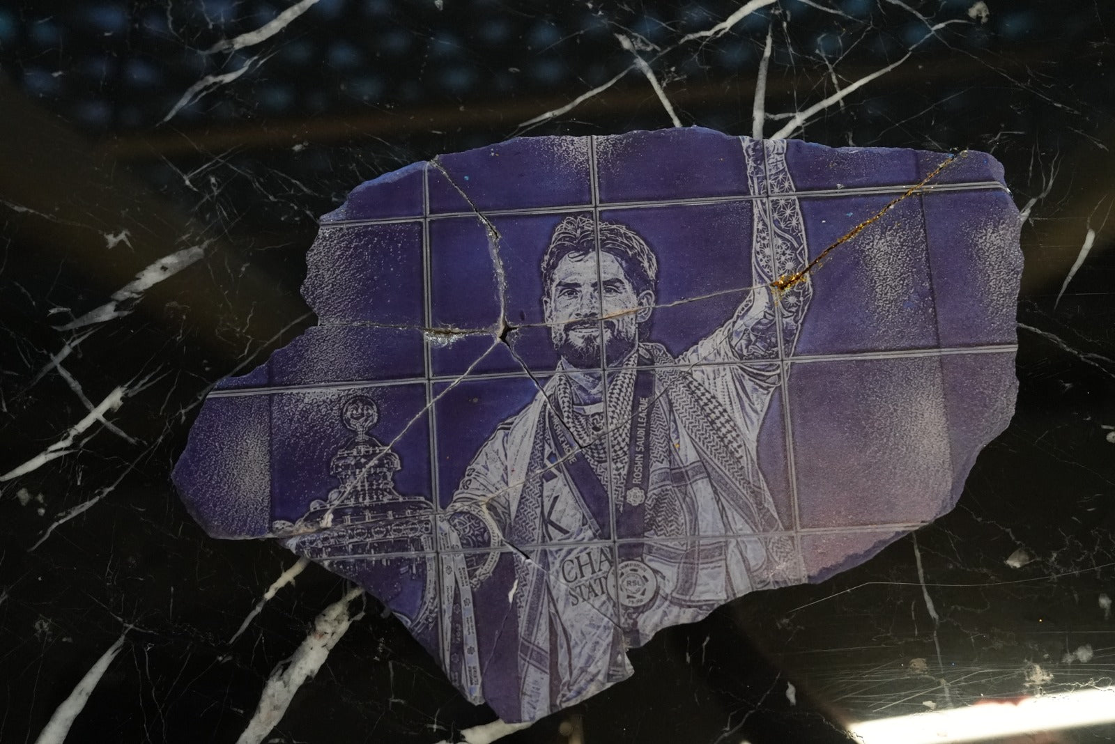 Al Nassr FC laser-engraved stone slab — champion player portrait with gold kintsugi cracks on marble surface